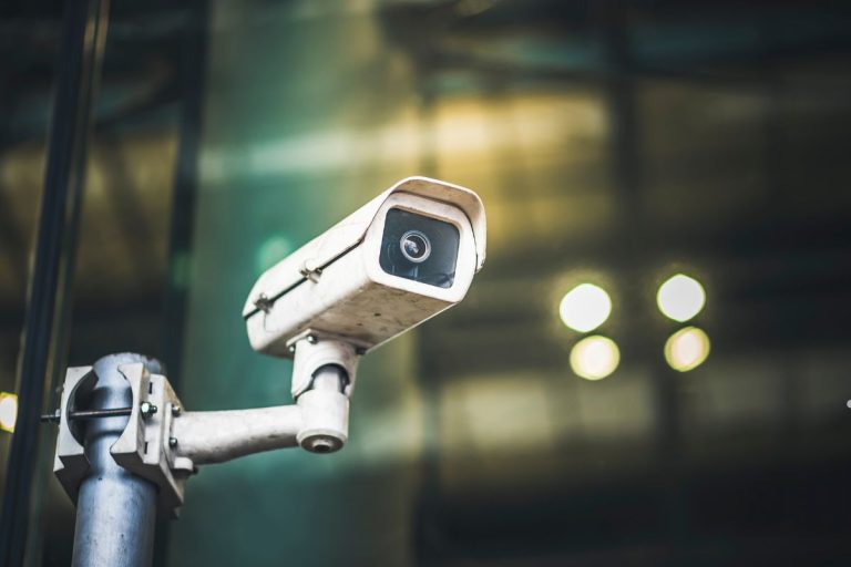A security camera mounted in front of a building, emphasizing business security measures.