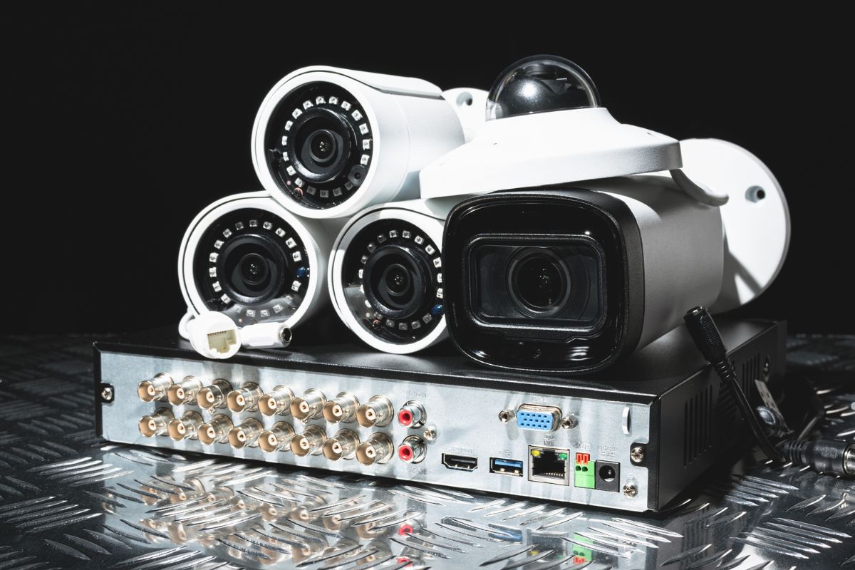  A group of four security cameras arranged on a metal surface, showcasing different styles and designs.